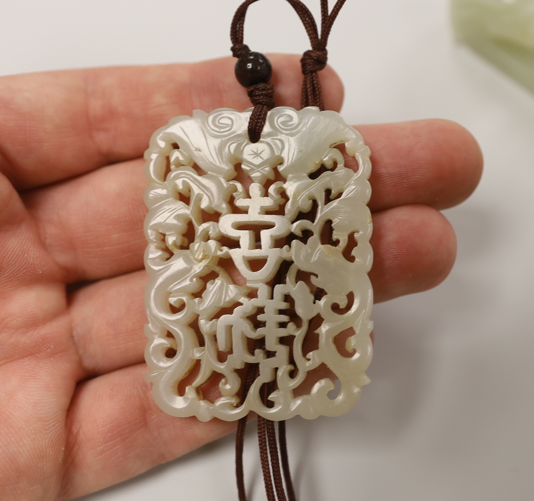 A Chinese pale celadon jade belt hook, 18th / 19th century and a similar 19th century pendant, pendant 5.5 cm long